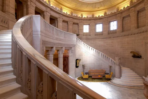 Indoor entrance with staircases on either side and couches on the ground floor