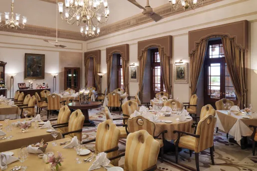 Indoor dining area with yellow striped cushioned chairs and wine glasses on the tables