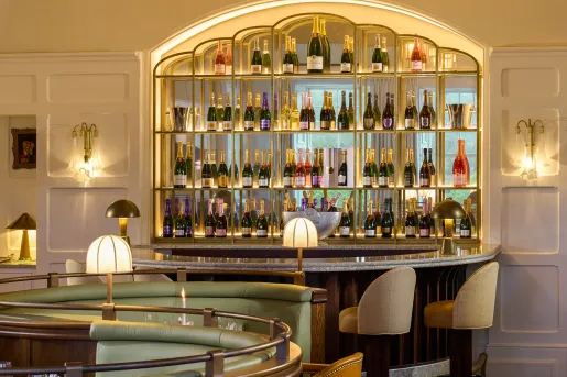 Crescent shaped bar with bottles of wine on the wall