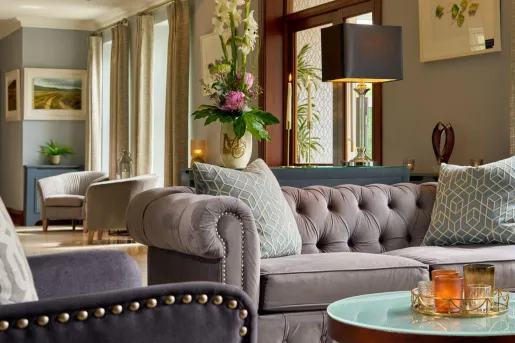Seating area with cushioned, gray sofa with a circular glass table in front