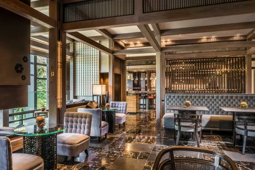 Indoor bar and lounge with marble floors and gray cushioned chairs