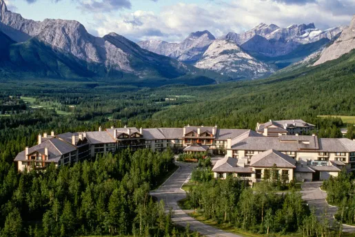 Long hotel building surrounded by a forest of trees