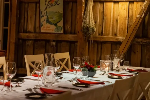 Indoor dining area with wooden walls and wine glasses on the tables