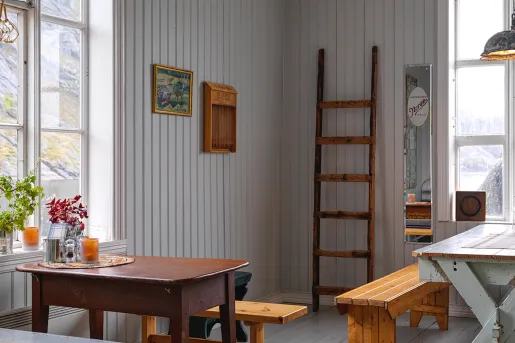 Indoor cabin lounge with tables and wooden benches