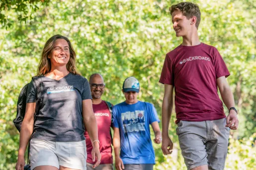 Group of men and women hiking in the middle of a forest