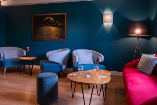 Lounge with blue cushioned seats and wine glasses on wooden tables