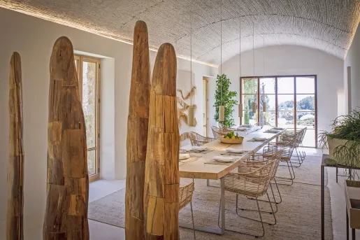 Indoor dining area with large, wooden art sculptures and large windows