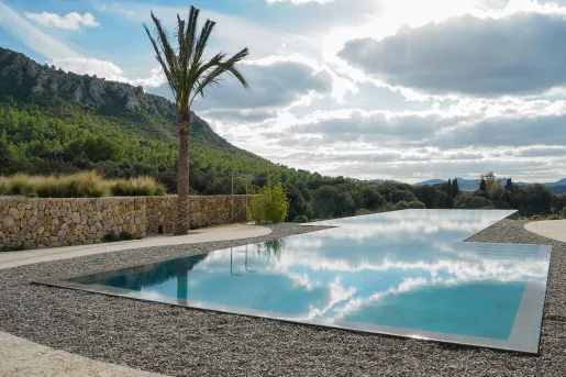 Outdoor infinity pool surrounded by stone and gravel