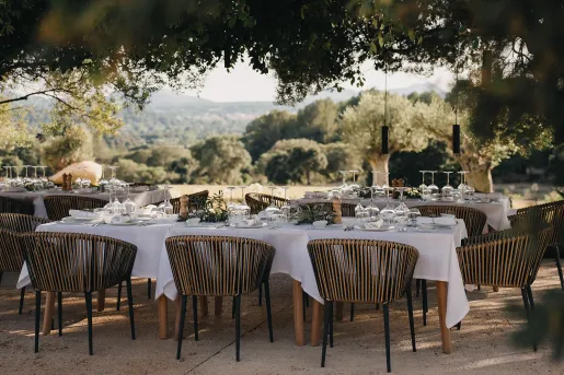 Outdoor dining area with white tablecloths and wooden chairs