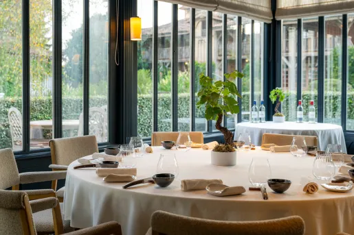Large circular dining table with cutlery and wine glasses around the table