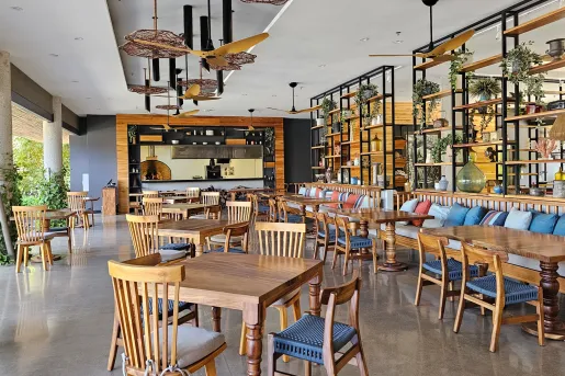Indoor dining area with large, open walls with stone pillars