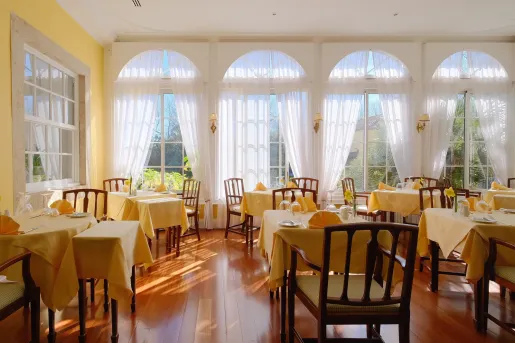 Indoor dining hall with yellow tables and wooden chairs