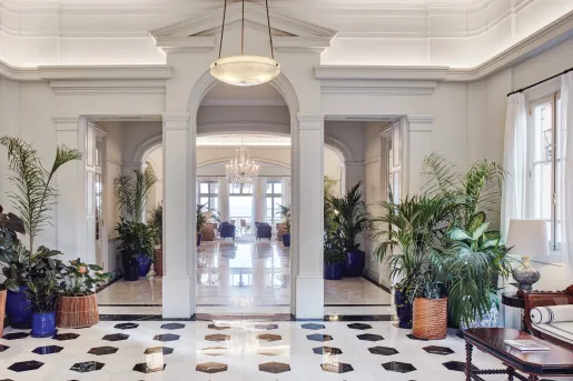Lobby with granite floors and plants in vases by the corners of the room