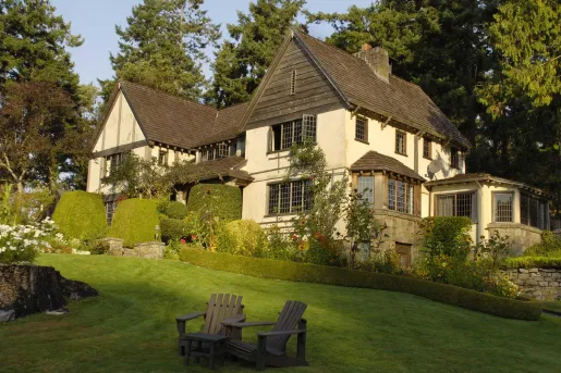 Rustic building surrounded by tall bushes and a grass slope