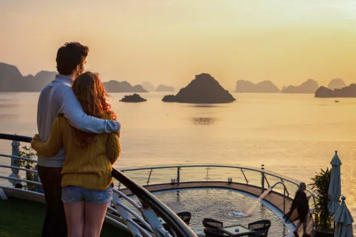 two people embracing and looking out at the sunset