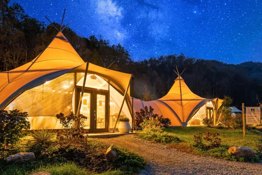 Illuminated white hut, with the midnight starry sky