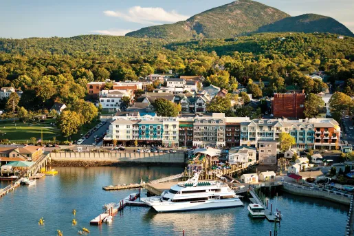 Coastline dock with a yacht and hotel buildings along the coast