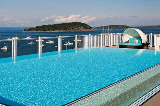 Outdoor pool overlooking the ocean, filled with boats