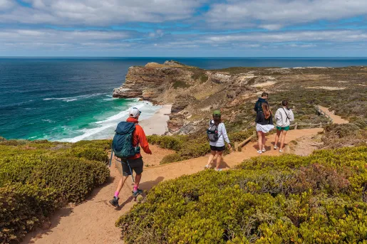 People hike down a beachfront road