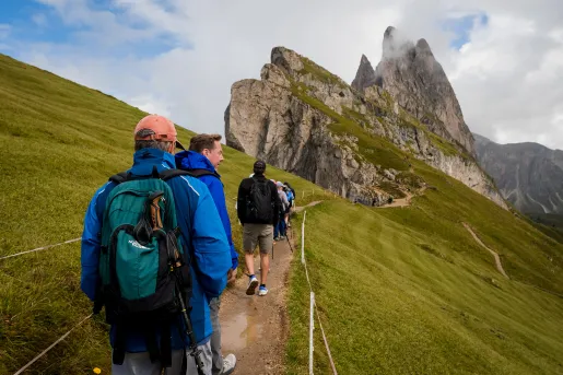 Hikers walking trail towards mountain