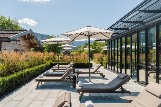 Outdoor patio with tan pool chairs and towels with open umbrellas