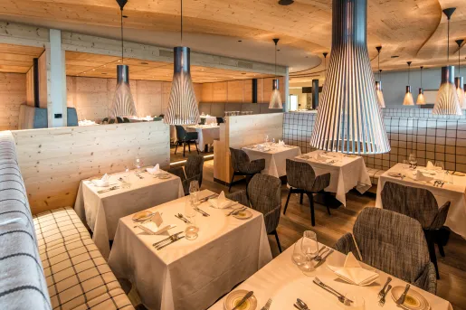 Indoor dining area with gray cushioned chairs and black light fixtures