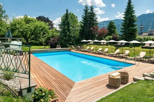 Outdoor pool surrounded by reclining chairs and umbrellas