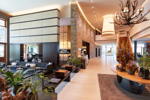 large hotel lobby with armchairs and grand staircase