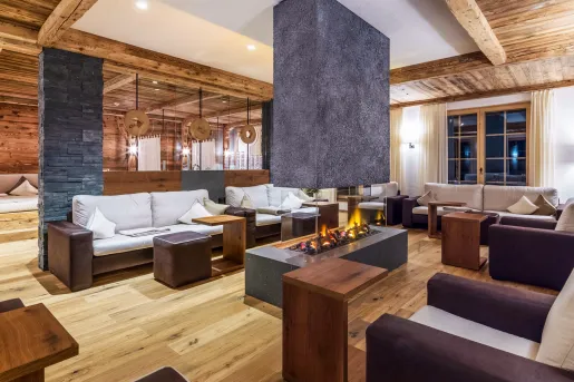 Brown and white couches surrounding a fireplace in a hotel lobby