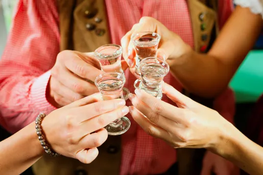 four shot glasses cheersing