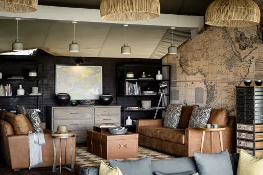 living room with leather couches, map wallpaper, and Raffa chandlier