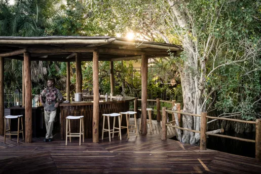 a man stands by a wooden outdoor bar