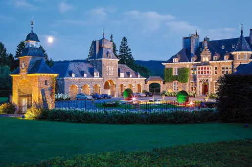 Stone buildings with nighttime lights surrounding the fence