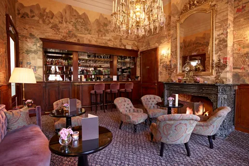 ornate living room with dark wallpaper and chandelier