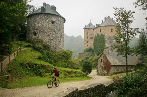 Stone towers and a man biking through the gravel trail