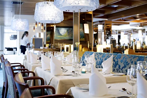 Waitress setting up dining area with wine glasses and folded handkerchiefs 
