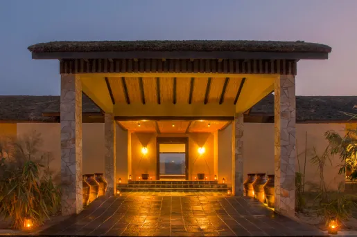 Stone building entrance, with a long path of stone and stone pillars