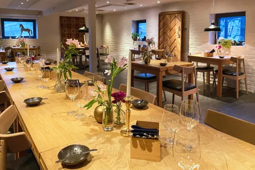 Long dining table with wine glasses and vases with flowers on top