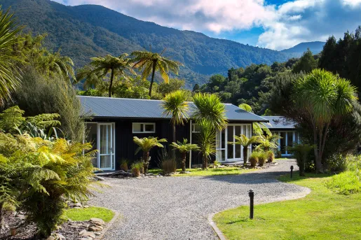Blue building surrounded by tall plants and a gravel pathway