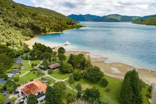 Coastline of a small beach  leadings towards smaller buildings 