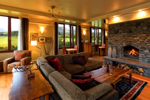 Indoor lounge area with a stone fireplace and woven cushioned seats