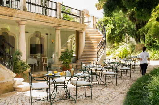 outdoor bistro tables next to a spiral staircase