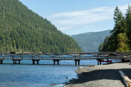 Wooden bridge over a lake and a gravel coast