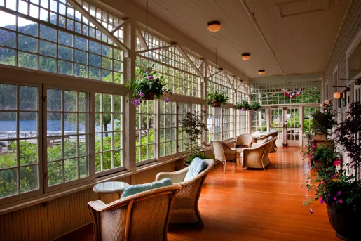 Woven chairs looking out towards the lake, surrounded by flowers