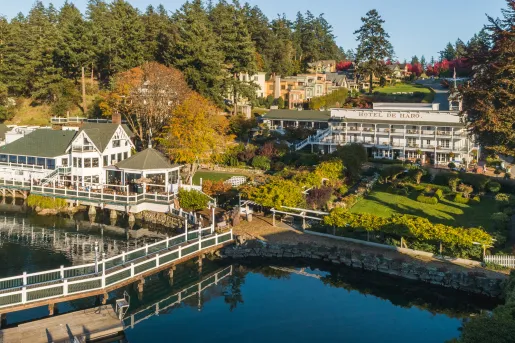 Sky view of a hotel building and harbor, with a large garden in between the two