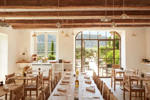 Indoor dining area with wine glasses on the tables, with a door leading to an outdoor patio