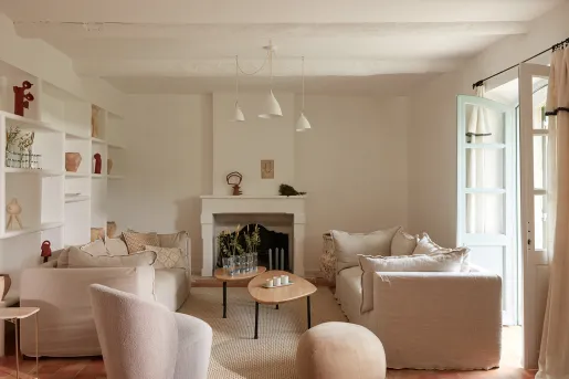 Indoor lounge with cushioned chairs with an open door on the right