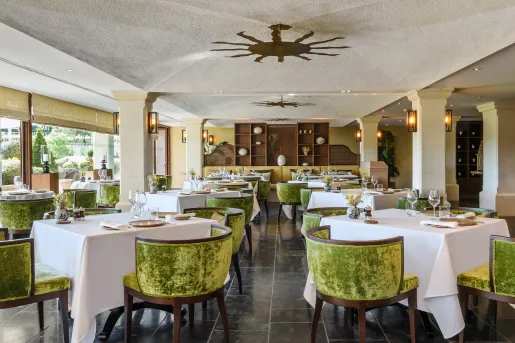 Indoor dining hall with velvet green cushioned chairs