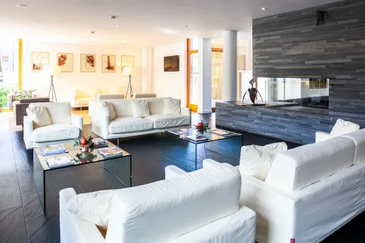 Indoor seating area with white, sofas and black stone flooring