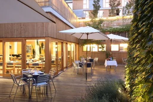 Outdoor patio with dining tables on a wooden planked floor